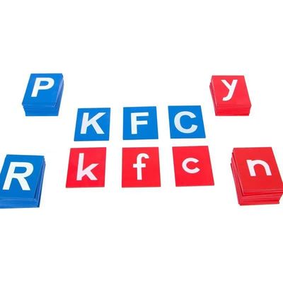 Младенец уча доски деревянного алфавита Montessori следуя