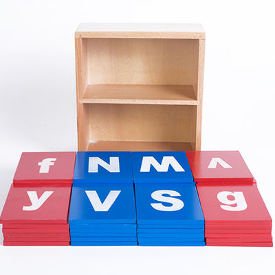 Младенец уча доски деревянного алфавита Montessori следуя